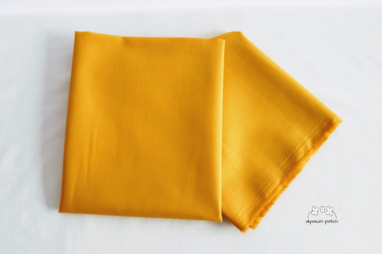 Kona Cotton Solids Grellow fabric folded